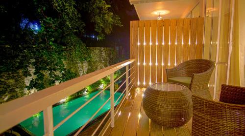 a balcony with a table and chairs and a swimming pool at 18 Faces with free drop off to Galle Fort by TukTuk in Galle