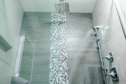 a shower in a bathroom with a glass shower backdoor at Admiral's Inn on Tybee Island in Tybee Island