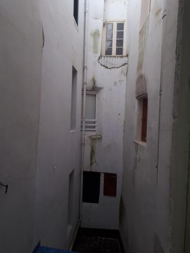 an empty alley with a white building and a window at Hotel De l'Europe in Meyrueis