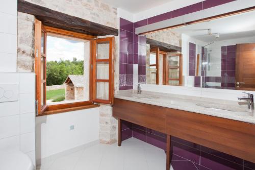 łazienka z dużą umywalką i lustrem w obiekcie Villa Poropati, Grožnjan, Istria - Luxury Countryside Estate for up to 19 persons - Large pool of 80m2 with kids section w mieście Grožnjan