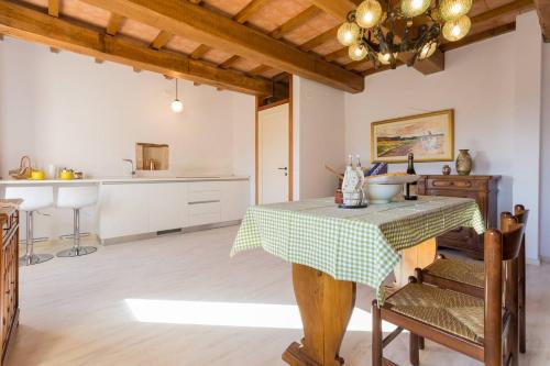 a dining room with a table and a kitchen at Villa Costanzi: Comfy Apartment Below The Cucco in Sigillo