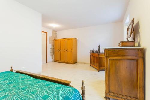 een slaapkamer met een bed en een houten kast bij Villa Costanzi: Comfy Apartment Below The Cucco in Sigillo
