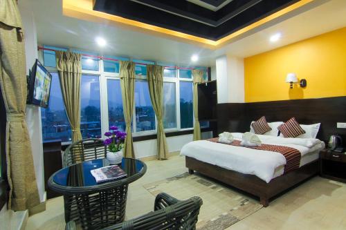 a bedroom with a bed and a table and chairs at Hotel Lakeside Pvt. Ltd. in Pokhara
