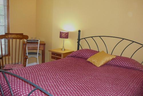 1 dormitorio con 1 cama con edredón morado en B&B La Bedondaine, en Quebec
