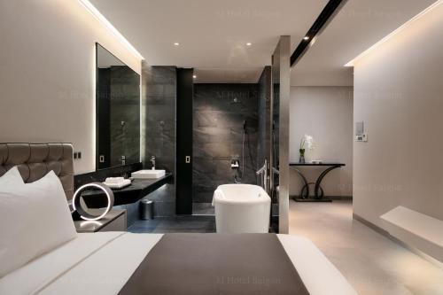 a bedroom with a bed and a bathroom with a shower at M Hotel Saigon in Ho Chi Minh City