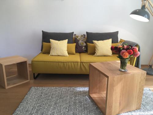 a living room with a yellow couch and a table at Bergblick Riedlern - Ferienwohnung in Kreuth