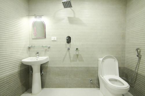 Hotel Lakeside Pvt. Ltd. في بوخارا: حمام ابيض مع مرحاض ومغسلة