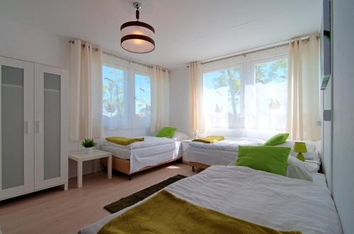 ヤロスワビエツにあるOśrodek Wczasowy Bryza Morska Jaroslawiecのベッドルーム1室(ベッド2台、ソファ、窓付)