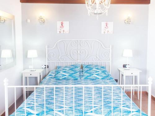 1 cama blanca en un dormitorio blanco con 2 mesas blancas en LAS MORADITAS, CHALET con PISCINA PRIVADA en Adeje