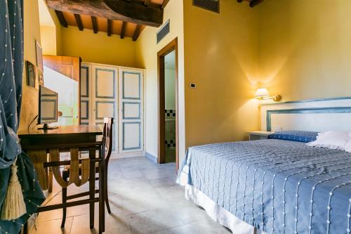 a bedroom with a bed and a desk and a table at Le Fonti A San Giorgio in Montespertoli