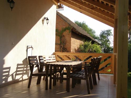 a wooden table and chairs on a patio at Őrségi Tornácos Vendégfogadó in Felsőszenterzsébet