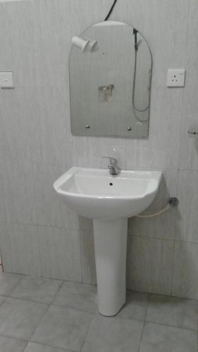 a white sink in a bathroom with a mirror at Masha Beach Inn in Tangalle