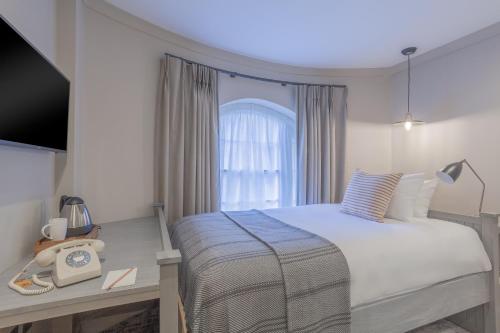 a bedroom with a bed and a window at Richmond Hill Hotel in Richmond upon Thames