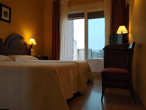 a hotel room with two beds and a window at Hotel Sierra de Andujar in Virgen de la Cabeza