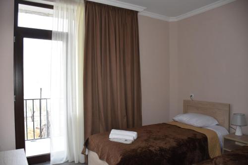 a hotel room with a bed and a window at Nikala's house in Borjomi