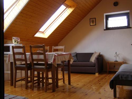 a living room with a table and a couch at Őrségi Tornácos Vendégfogadó in Felsőszenterzsébet