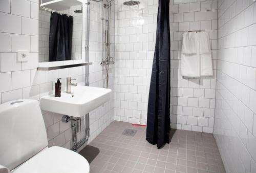 a white bathroom with a sink and a toilet at The Studio Hotel in Stockholm