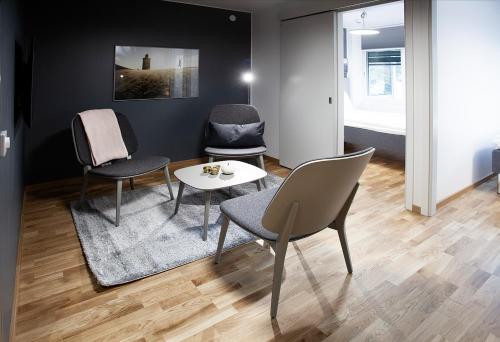 a living room with chairs and a table and a couch at First Hotel The Studio in Stockholm