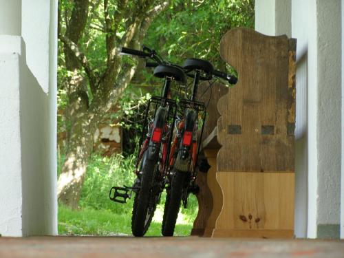 a bike is parked next to a wooden sign at Őrségi Tornácos Vendégfogadó in Felsőszenterzsébet