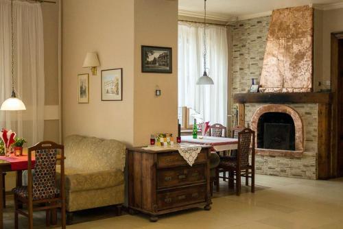 a living room with a couch and a table and a fireplace at Hotel Karkonosze in Kamienna Góra