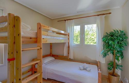 a bedroom with two bunk beds and a potted plant at Villas Guzman - Chirla in Calpe