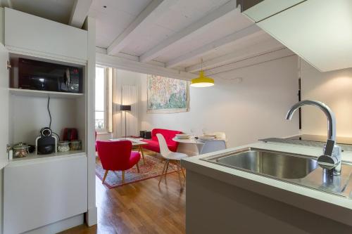 kuchnia ze zlewem i czerwonymi krzesłami w pokoju w obiekcie Opéra - Appartement 2beapart w mieście Lyon