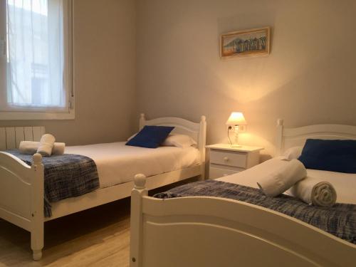 two white beds in a room with a window at Easo amplio y funcional cerca de la playa. in San Sebastián