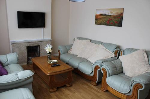 a living room with two couches and a coffee table at 25 Idmiston Road in London