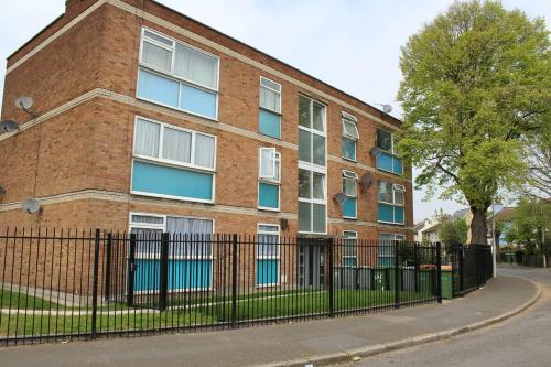 a brick building with a fence in front of it at 25 Idmiston Road in London