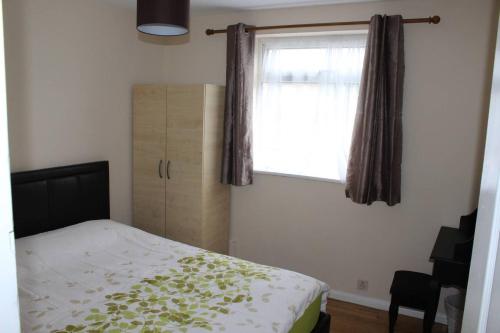 a bedroom with a bed and a window at 25 Idmiston Road in London