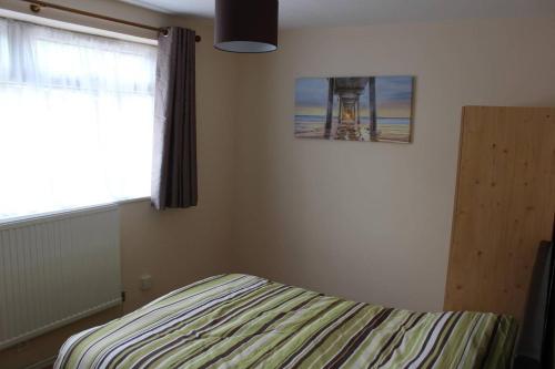 a bedroom with a bed and a window with a lighthouse at 25 Idmiston Road in London