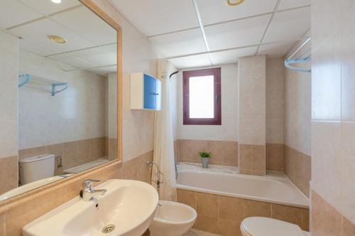 La salle de bains est pourvue d'un lavabo, de toilettes et d'une baignoire. dans l'établissement Villas Guzman - Apartamento Coral Beach, à Calp