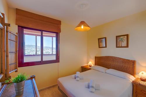 a bedroom with a bed and a large window at Villas Guzman - Apartamento Coral Beach in Calpe