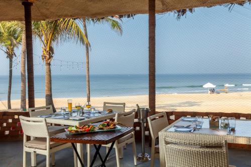 a table and chairs on a beach with the ocean at Caravela Beach Resort in Varca