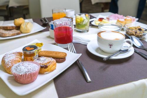 a table topped with plates of food and a cup of coffee at Hotel Villa Tirreno in Tarquinia