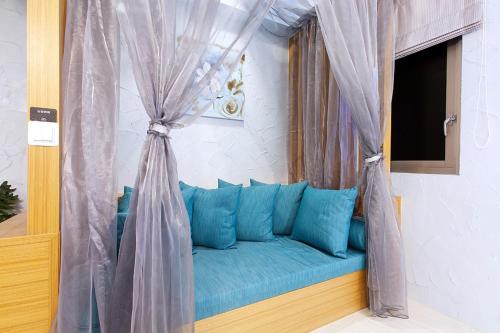 a blue couch in a room with a window at Discovery Motel - Yanping in Taipei