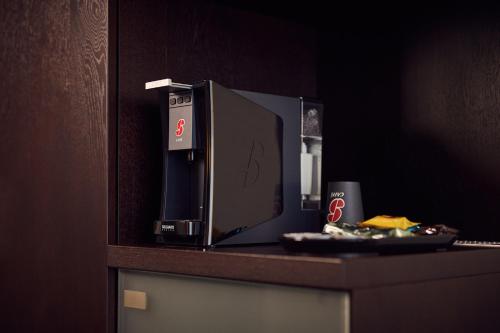 a microwave sitting on top of a counter at Hotel Charleroi Airport - Van Der Valk in Charleroi