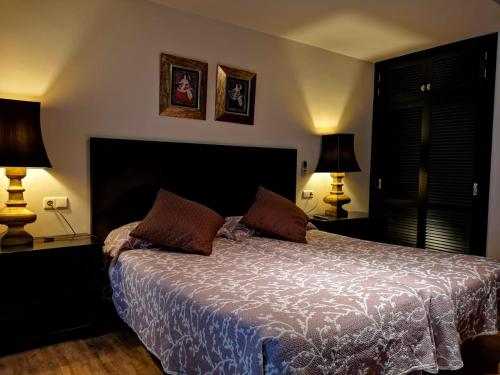 a bedroom with a large bed with two lamps at Hostal Tres Soles in Nerja