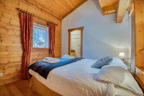 une chambre avec un lit dans une cabane en rondins dans l'établissement Clos 3 - Chamonix, à Chamonix-Mont-Blanc