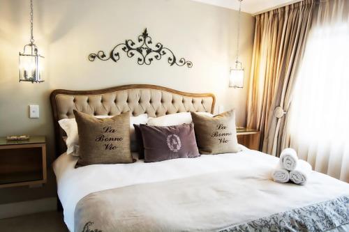 a bedroom with a bed with pillows on it at Avemore Lagratitude No 6 - with backup power for loadshedding in Stellenbosch