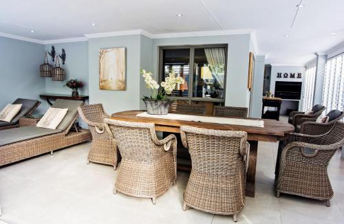 a dining room with a table and wicker chairs at Avemore Lagratitude No 6 - with backup power for loadshedding in Stellenbosch