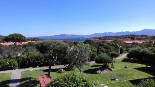 a garden with a view of the water and mountains at Residenze Coda Cavallo in San Teodoro