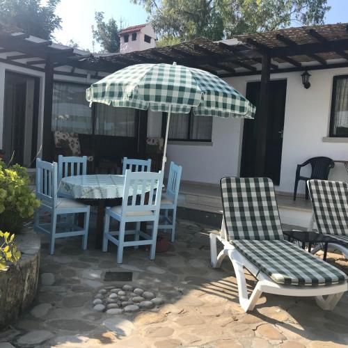 a table and chairs and an umbrella on a patio at Hidden Cottage in Kyrenia