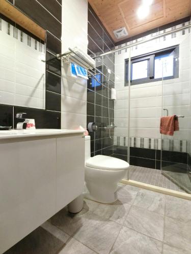 a bathroom with a toilet and a glass shower at 吉祥城堡 Propitious Castle B&B in Zhixue