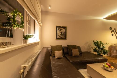 a living room with a brown couch and a window at Apartment NS Life in Novi Sad