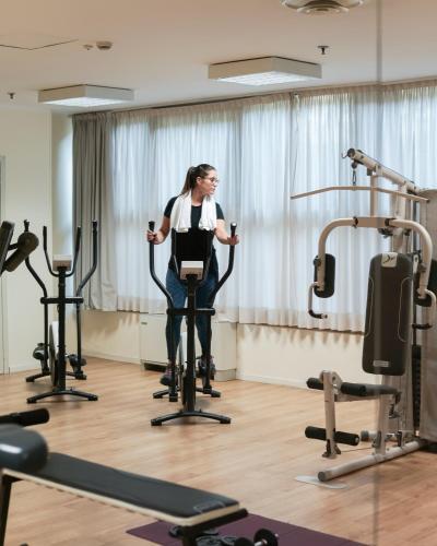 a woman standing in a room with exercise equipment at Best Western CTC Hotel Verona in San Giovanni Lupatoto