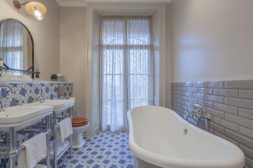 a bathroom with a tub and two sinks and a toilet at Richmond Hill Hotel in Richmond upon Thames