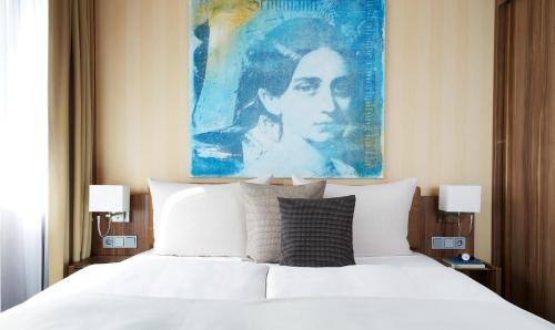 - une chambre avec un lit orné d'une peinture murale dans l'établissement Living Hotel Düsseldorf, à Düsseldorf