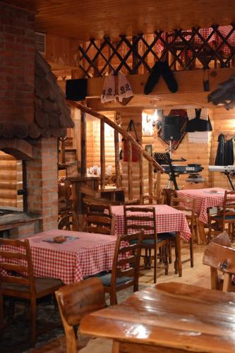 un restaurante con mesas y sillas y una chimenea en Hotel "Srbija Tis", en Zajecar
