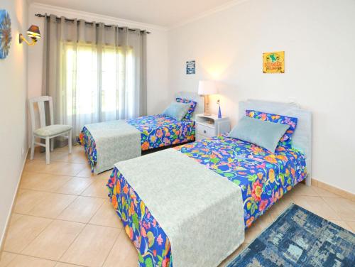 a bedroom with two beds and a chair at Bogart at Casablanca by OCvillas in Albufeira